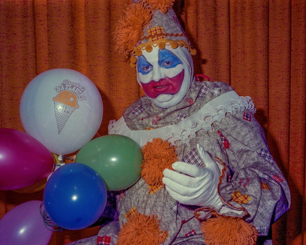 A clown holding balloons.